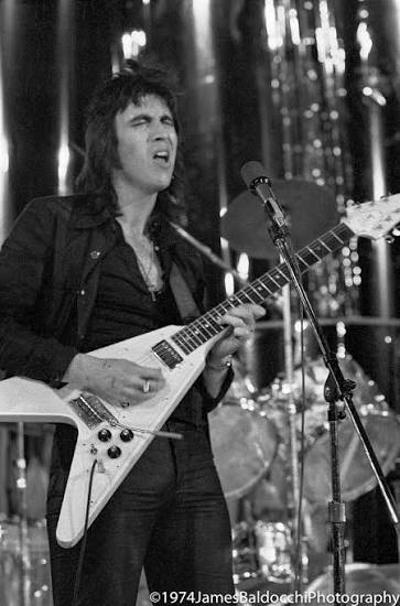 Bill Spooner on stage in 1974, singing at the mic with a Gibson Flying V