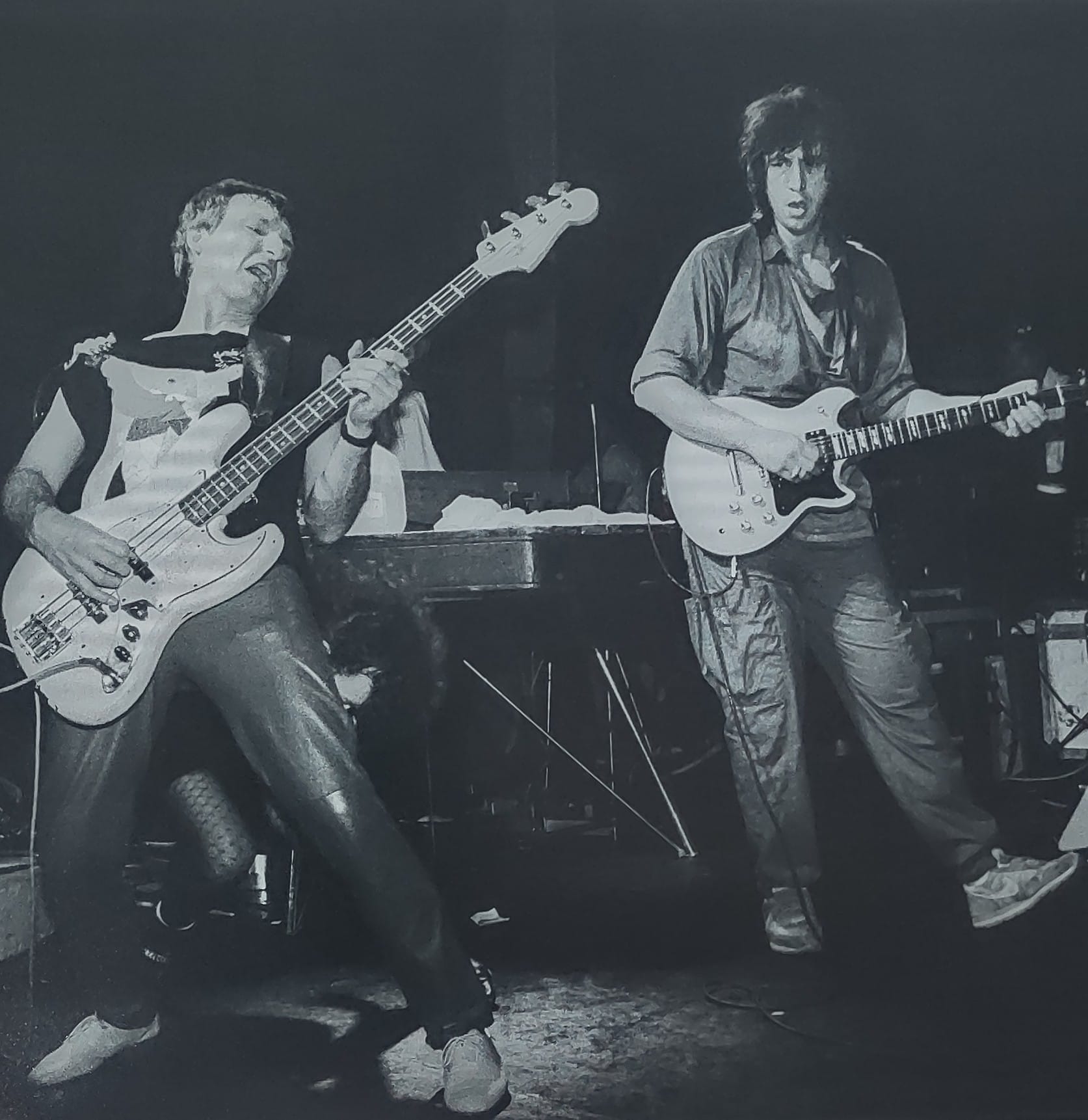 Bassist and Bill Spooner on guitar performing on stage, black-and-white live shot