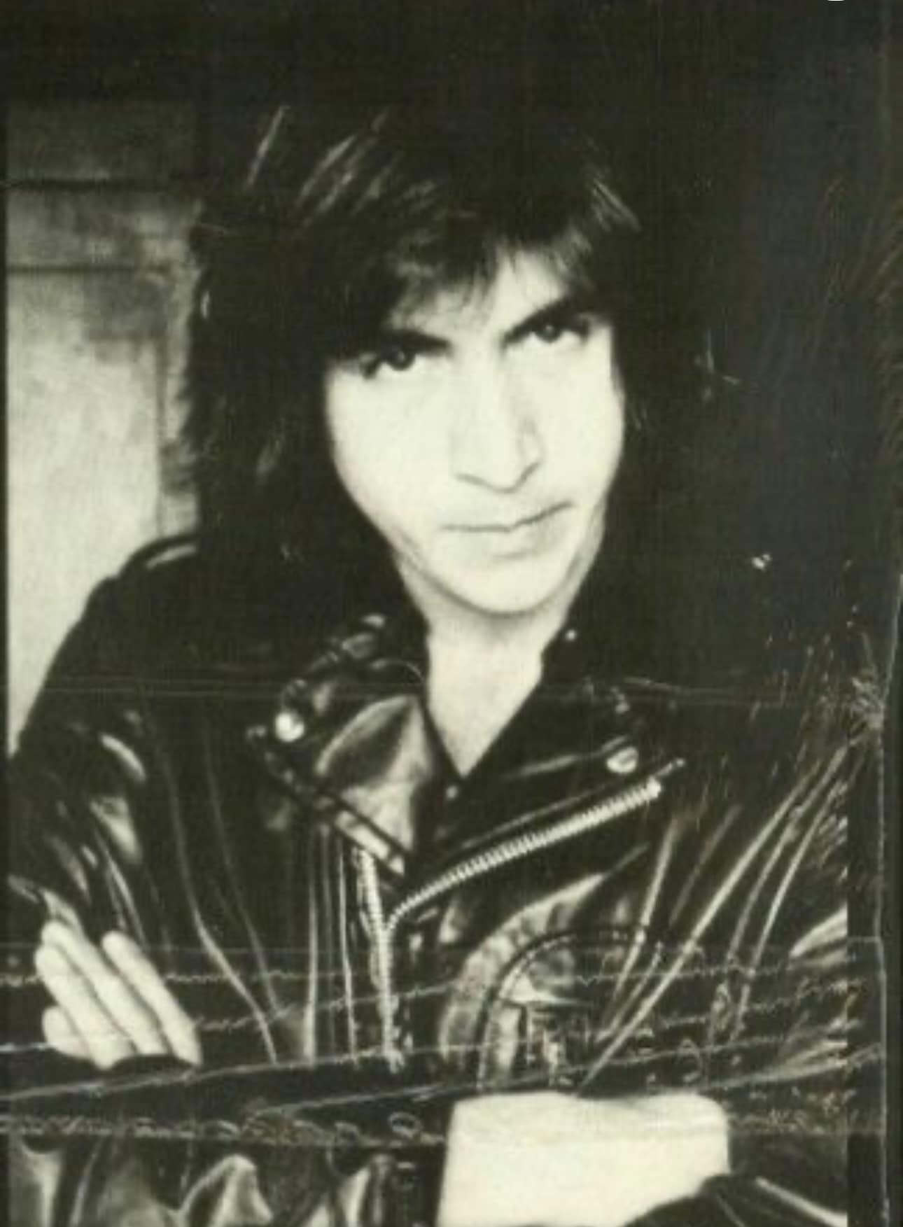 Bill Spooner — early portrait in a leather jacket, arms folded, intense gaze, black-and-white