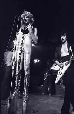 Quay Lewd on the mic stand with Bill Spooner beside him playing a white Flying V, black and white