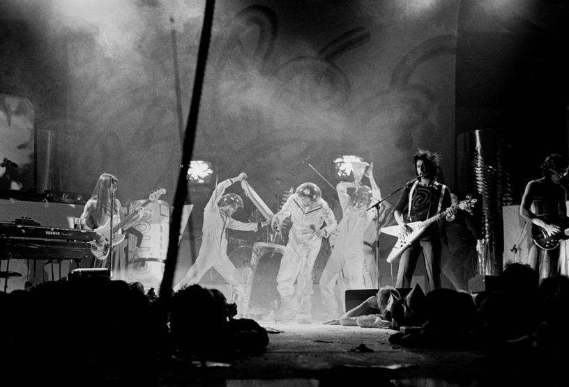 The Tubes on a smoke-filled stage with Quay Lewd center — moody black and white