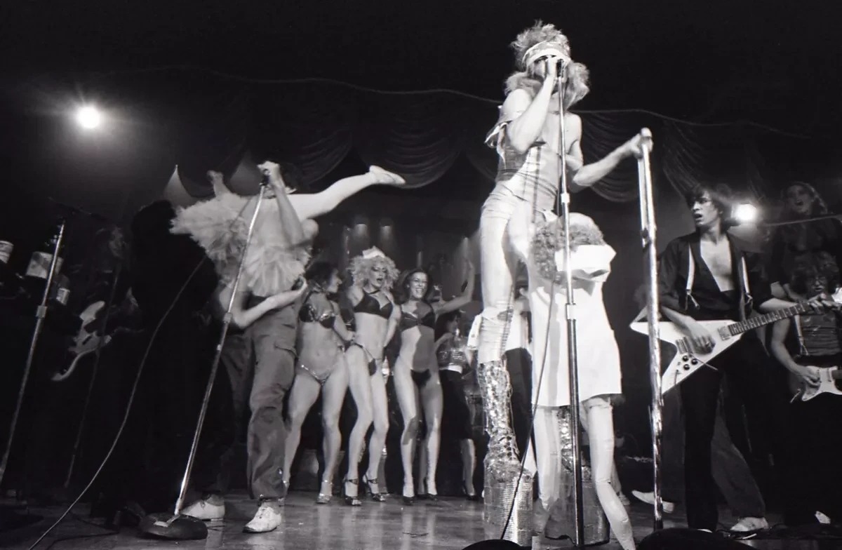 The Tubes live in San Francisco, 1977 — Quay Lewd center stage in platform boots, a line of dancers in bikinis behind him