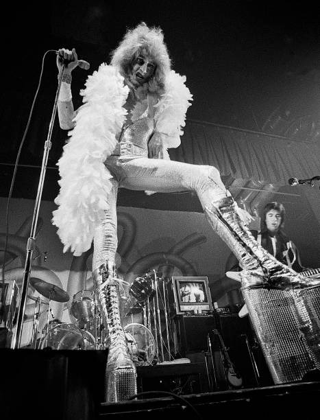 Fee Waybill as Quay Lewd on stage with platform boots